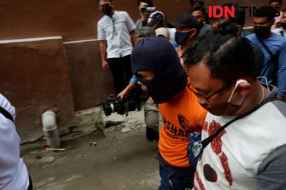 Tersangka pembunuh anak tiri Rahmadsyah (30) digelandang polisi ke TKP, Senin (22/6) (IDN Times/Prayugo Utomo)