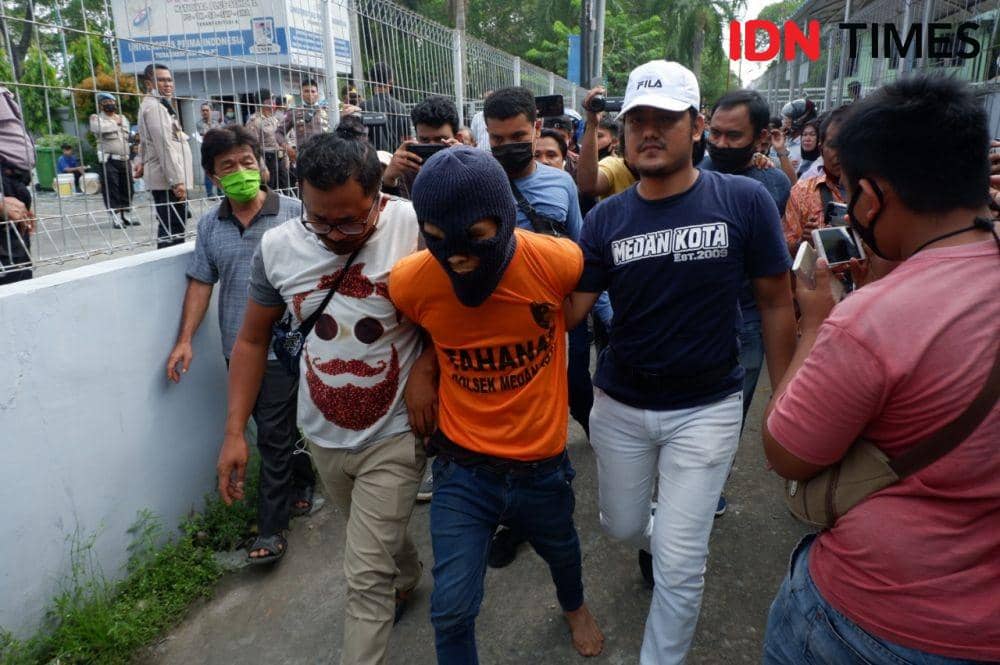 Tersangka pembunuh anak tiri Rahmadsyah (30) digelandang polisi ke TKP, Senin (22/6) (IDN Times/Prayugo Utomo)