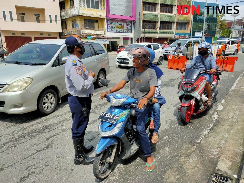 Petugas menegur warga yang melintas tanpa mengenakan masker (IDN Times / Hilmansyah)