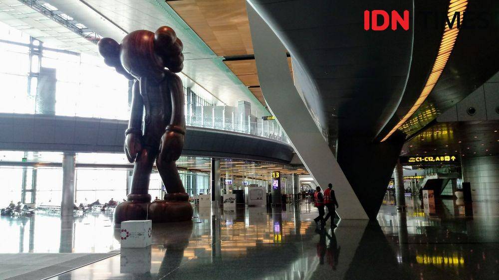 Seni patung karya KAWS berjudul 'Small Lie' menjulang di dalam terminal bandara Hamad International Airport, Doha, Qatar IDN Times/Yogie Fadila