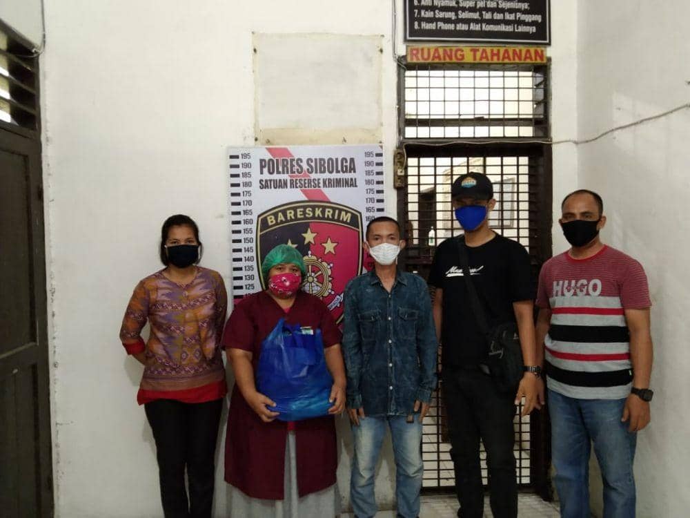Tersangka EWP (kemeja merah) saat diapit petugas Kepolisian Kota Sibolga (Istimewa/Dok IDNTimes)