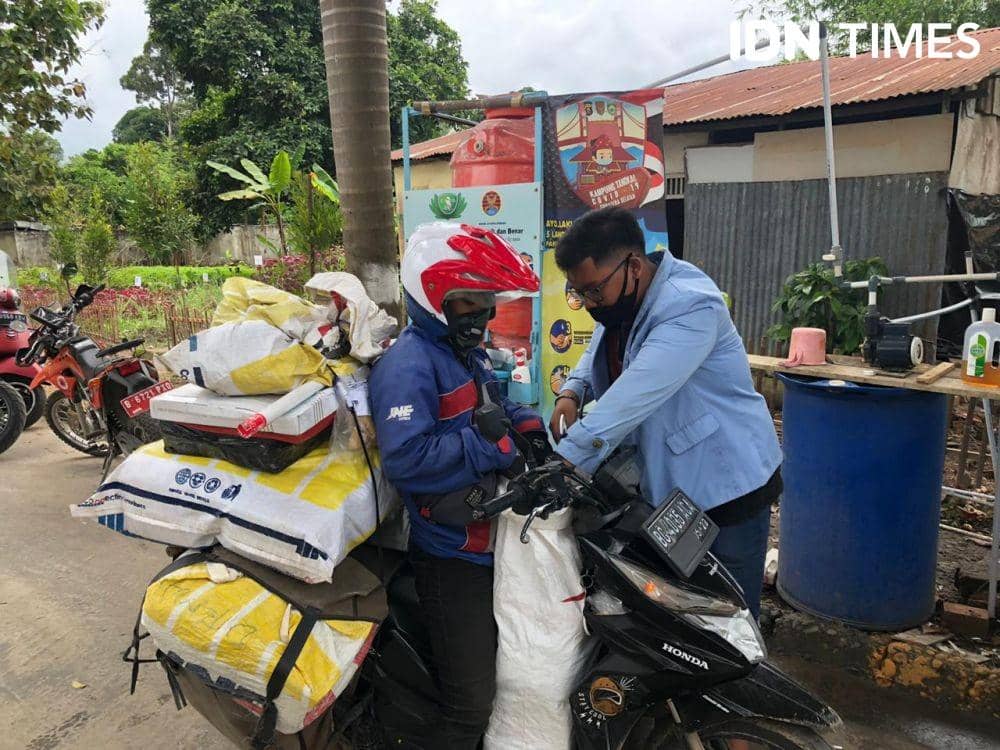 Pengantar paket disemprot disinfektan terlebih dahulu sebelum masuk kampung (IDN Times/Rangga Erfizal)