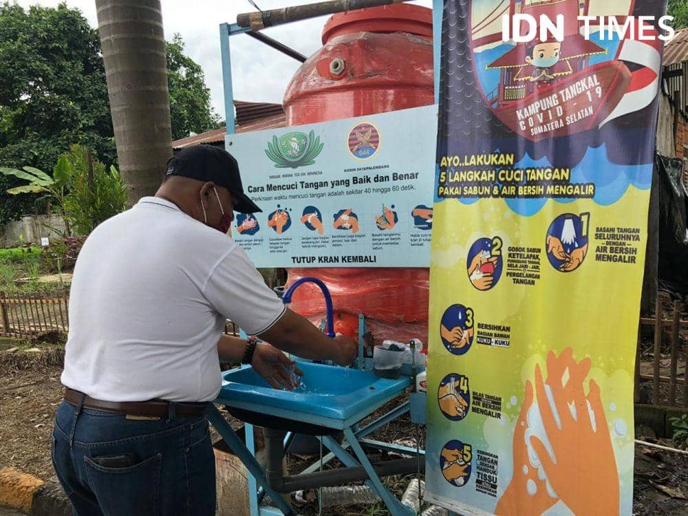 Warga yang mencuci tangan sebelum masuk ke dalam kampung (IDN Times/Rangga Erfizal)