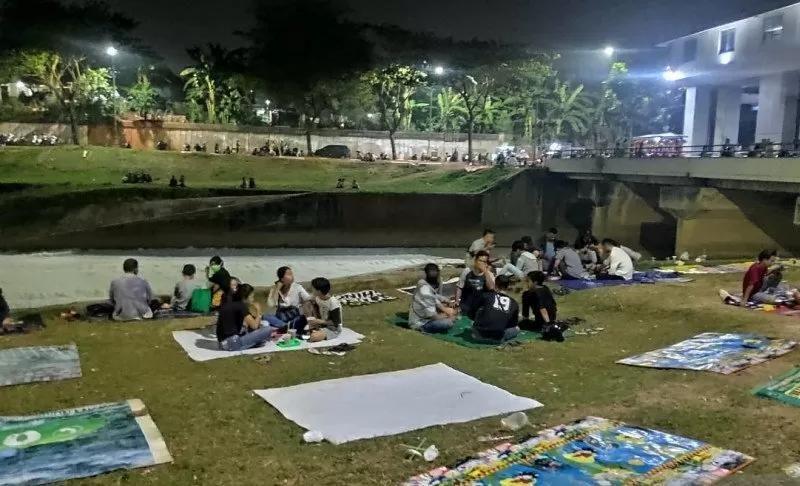 Warga Jakarta meluangkan waktu untuk bersantai di bantaran Sungai Banjir Kanal Timur, Jakarta Timur, Rabu (1/7/2020). Gumpalan busa serupa salju menjadi pemandangan unik bagi pendatang untuk sekadar melepas lelah usai bekerja (ANTARA/Andi Firdaus)
