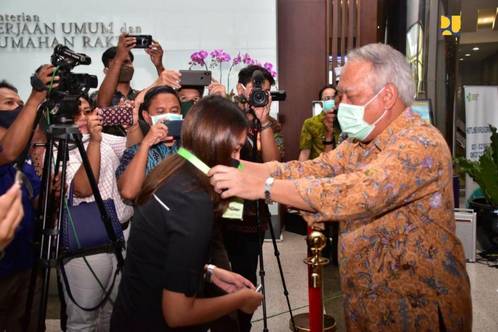 Menteri PUPR Basuki Hadimuljono mengenakan kalung antivirus corona ke salah satu jurnalis (Dok. IDN Times/KemenPUPR)