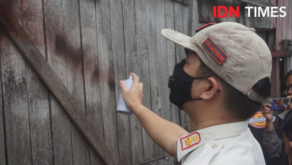 Petugas Satpol PP Samarinda saat memberikan tanda di salah satu rumah RT 28. Nantinya rumah ini akan dibongkar. (IDN Times/Yuda Almerio)