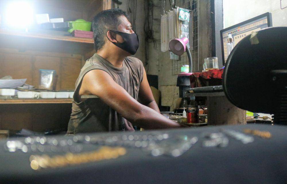 Pengrajin tengah membuat desain yang akan diaplikasikan pada logam stainless. IDN Times/ Alfi Ramadana
