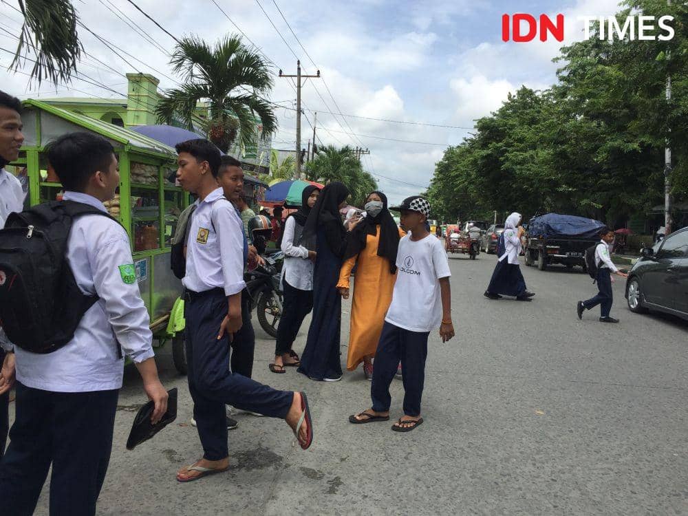 Siswa hari pertama masuk sekolah dengan seragam (IDN Times/Doni Hermawan)