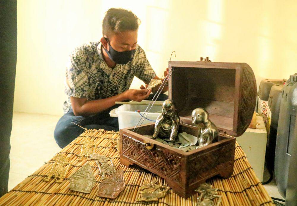 Jonathan Adi Prabowo saat mengerjakan finishing souvenir dari logam. IDN Times/ Alfi Ramadana