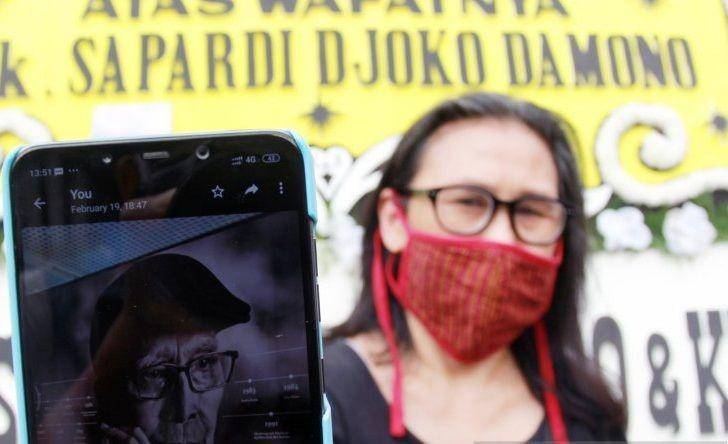Seorang kerabat menunjukkan foto almarhum Sapardi Djoko Damono di rumah duka di rumah duka Ciputat, Tangerang Selatan, Banten, Minggu (19/7/2020). (ANTARA FOTO/Muhammad Iqbal)