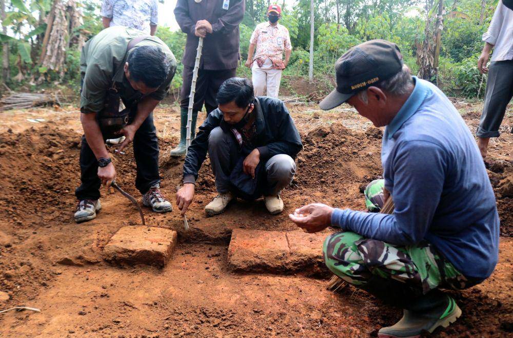 Petugas BPCB dibantu warga saat melakukan pembersihan terhadap struktur bata kuno di Desa Langlang. IDN Times/ Alfi Ramadana