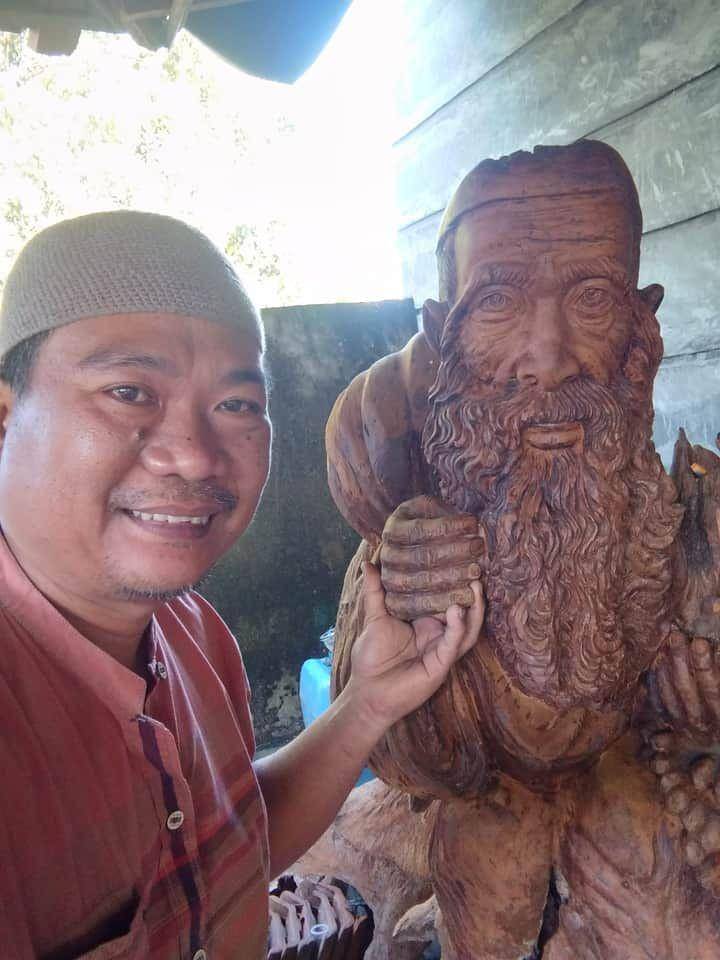 Abdullah Nurwawi Ali, seorang guru Sekolah Menengah Negeri (SMP) Negeri 1 Trimurjo Kabupaten Lampung Tengah, membuat kerajinan patung berbahan batang akar kayu. (Istimewa/IDN Times)