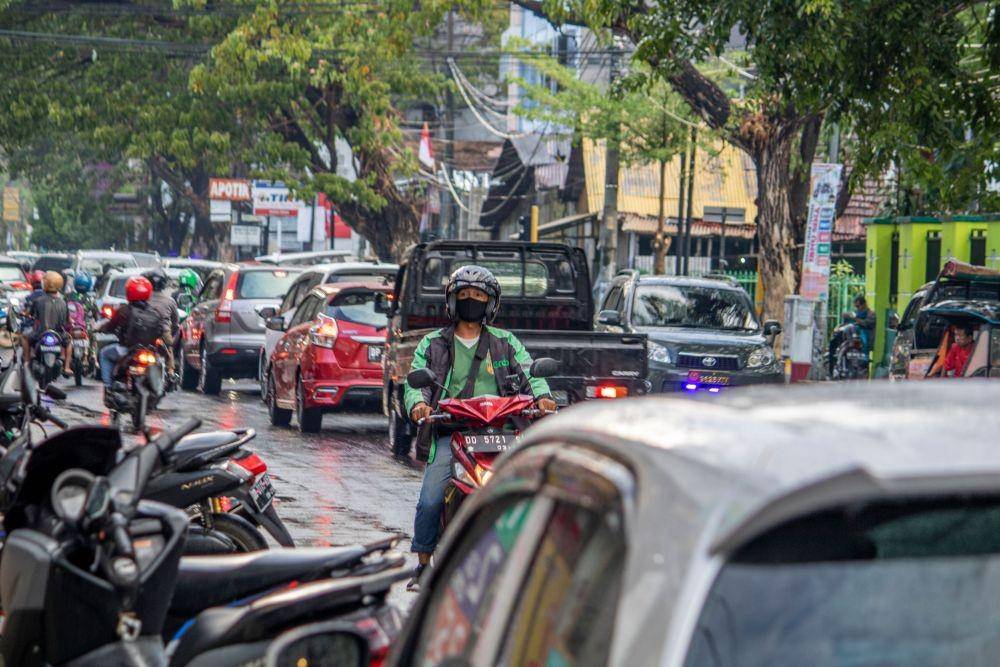 Seorang pengendara ojek online (daring) sedang melintas di Jalan Bulu Kunyi, Kelurahan Maricayya Baru, Kecamatan Makassar, Kota Makassar, Sulawesi Selatan. (Ari Putra Anugrah for IDN Times)