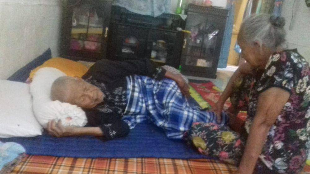 Sakiman yang terbaring di tempat tidur didampingi sang istri (IDN Times/Gideon Aritonang)