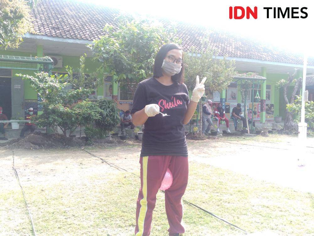 Lomba membawa kelereng dalam sendok dengan mengempit bola. IDN Times/Daruwaskita