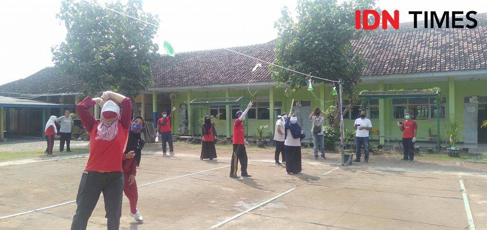 Lomba memukul balon lambang COVID-19 yang berisi air dengan mata ditutup kain. IDN Times/Daruwaskita