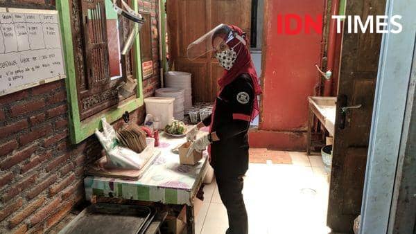 Simulasi mitra GoFood menerapkan J3K saat memroses pesanan pelanggan - IDN Times/Rijalu Ahimsa