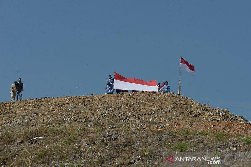 Kader Bela Negara, Srikandi Merah Putih dan Alumni Parade Cinta Tanah Air, kibarkan bendera di bukit sampah, Kota Banda Aceh (Foto: Antara)