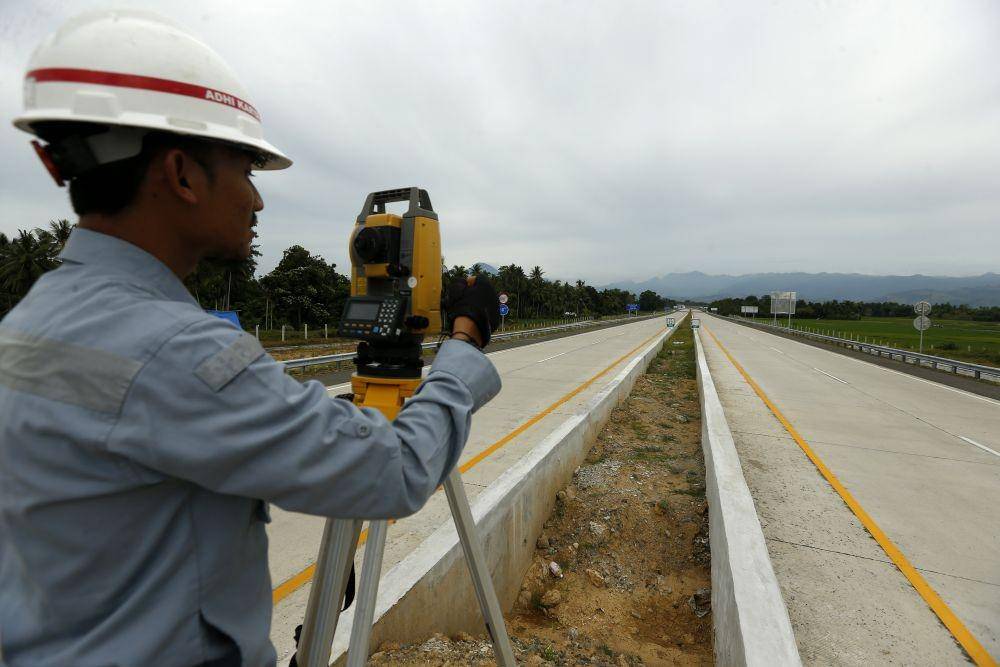 Pekerja mengukur jalan tol seksi IV Indrapuri - Blang Bintang di Aceh Besar, Aceh, Senin (6/7/2020) (ANTARA FOTO/Irwansyah Putra)