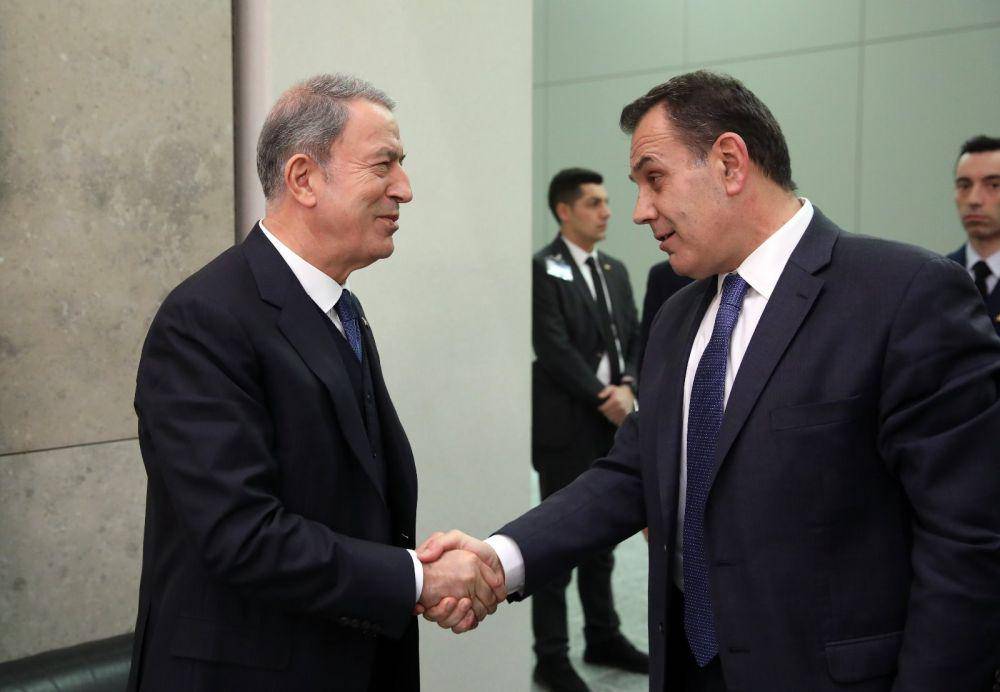 Menteri Pertahanan Turki Hulusi Akar (kiri) berjabat tangan dengan Menteri Pertahanan Yunani Nikos Panagiotopoulos. Twitter.com/tcsavunma.