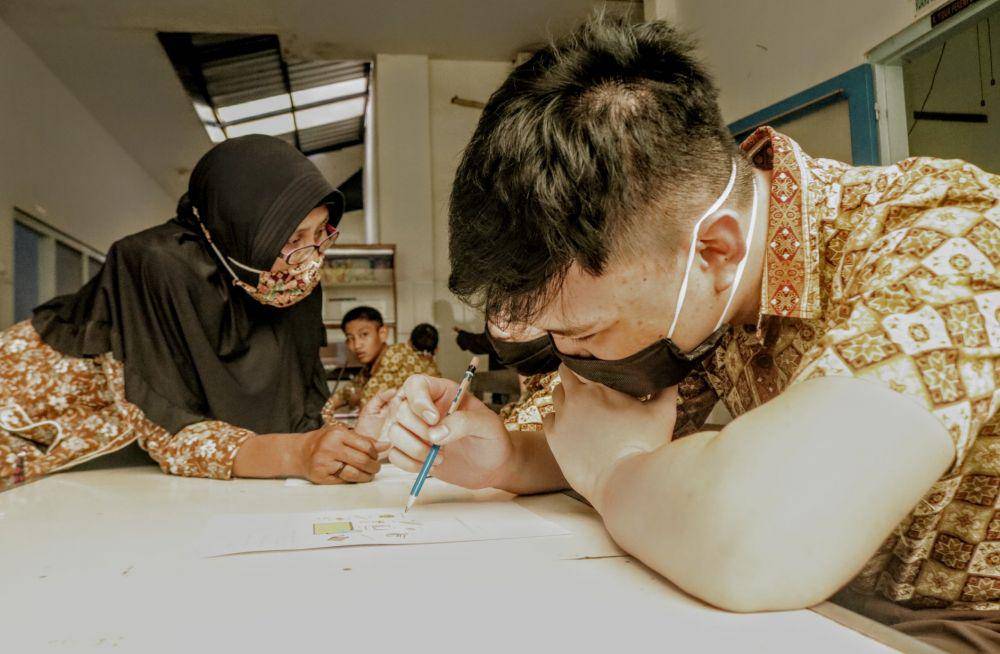 Seorang siswa berkebutuhan khusus mengikuti proses belajar tatap muka dengan protokol COVID-19. IDN Times/ Alfi Ramadan