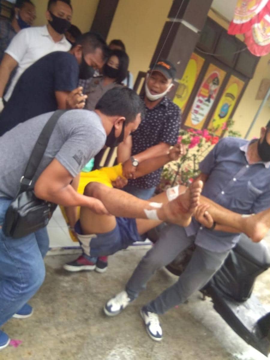 Pelaku perampokan sejumlah minimarket harus dibopong petugas karena kedua kakik nya tertembak (IDN Times/ IDN Times/ Bambang Suhandoko)