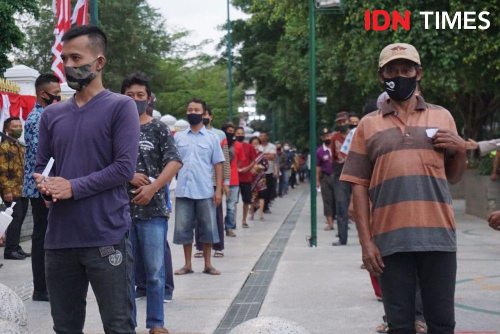 Warga mengantre dengan tertib untuk menerima paket sembako. (IDN Times/Tunggul Damarjati)