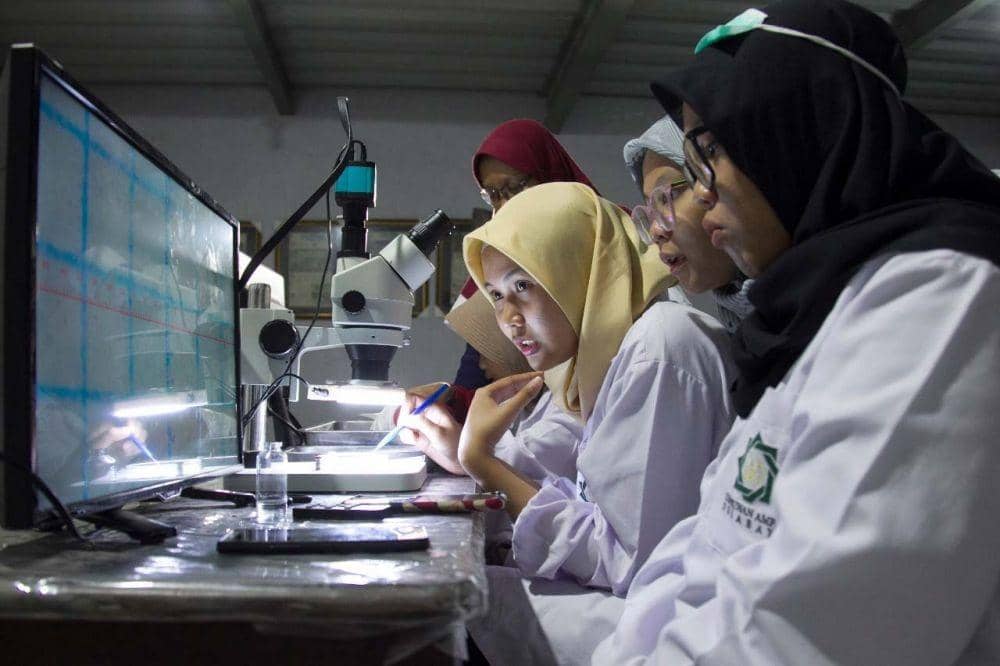 TCC saat meneliti sampel air sungai di kawasan Gresik. IDN Times/Dok. Istimewa