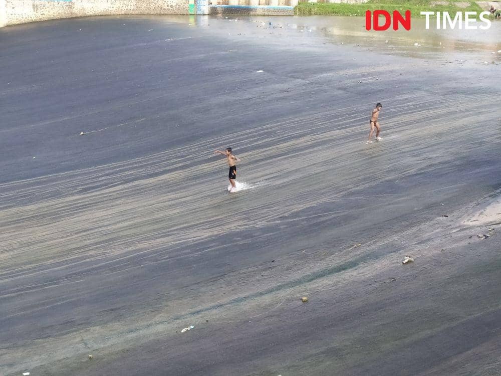 Dua bocah di Semarang bermain perosotan di bawah bendungan Banjir Kanal Barat. IDN Times/Fariz Fardianto