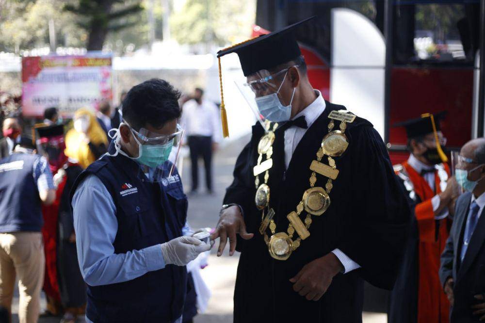 Rektor UMM diperiksa suhu tubuhnya sebelum memasuki ruang prosesi wisuda. Dok/Humas UMM