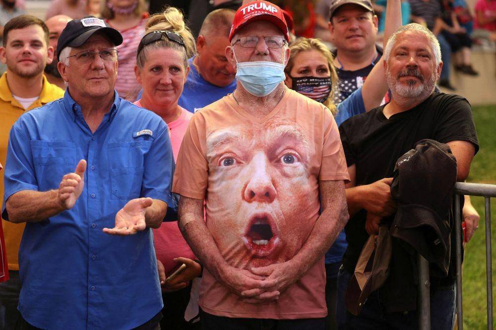 Pendukung Trump, salah satunya memakai dengan wajah Presiden Amerika Serikat Donald Trump, mendengarkan Trump berbicara dalam sebuah acara kampanye di Bandara Regional Smith Reynolds di Winston-Salem, North Carolina, Amerika Serikat, Selasa (8/9/2020) (ANTARA FOTO/REUTERS/Jonathan Ernst)
