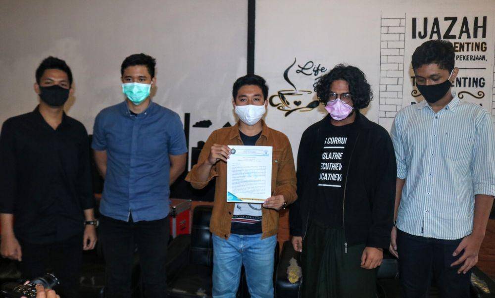 Perwakilan BEM Universitas Brawijaya menunjukkan catatan penolakan terhadap pengesahan Omnibus Law. IDN Times/ Alfi Ramadana