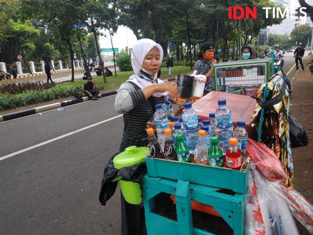 Orimah (Kanan) dan keponakannya nekat berjualan minuman di tengah kerusuhan di wilayah Harmoni, Jakarta Pusat, Kamis (8/10/2020). (IDN Times/Ilyas Mujib (IDN Times/Ilyas Mujib)