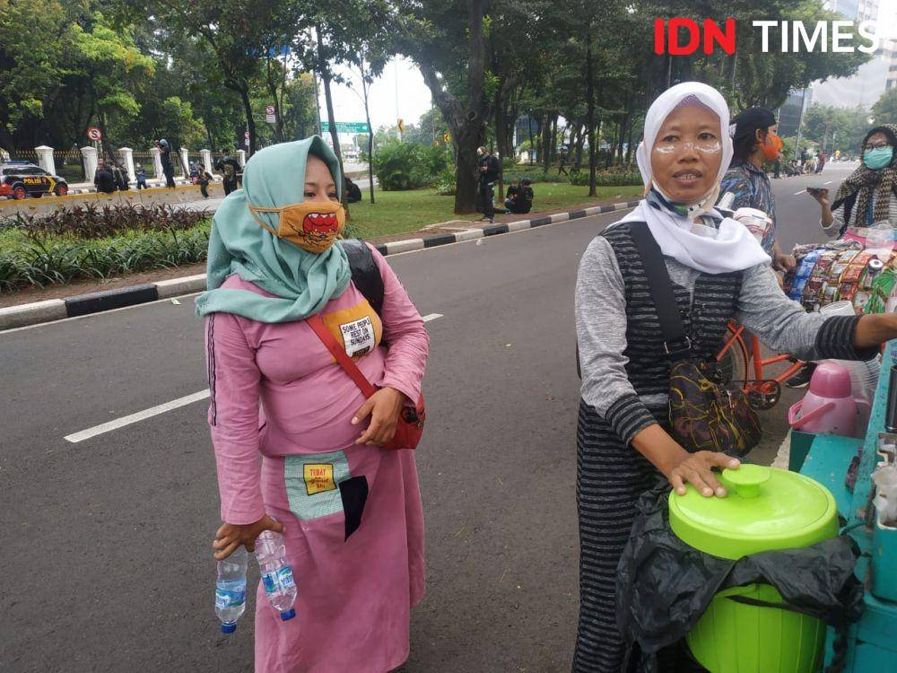 Orimah (Kanan) dan keponakannya nekat berjualan minuman di tengah kerusuhan di wilayah Harmoni, Jakarta Pusat, Kamis (8/10/2020). (IDN Times/Ilyas Mujib (IDN Times/Ilyas Mujib)