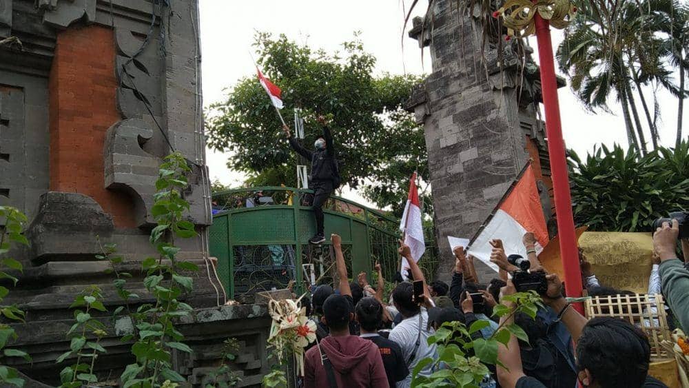 Pengibaran bendera merah putih di atas pagar pintu masuk DPRD Bali (IDN Times/Ayu Afria)