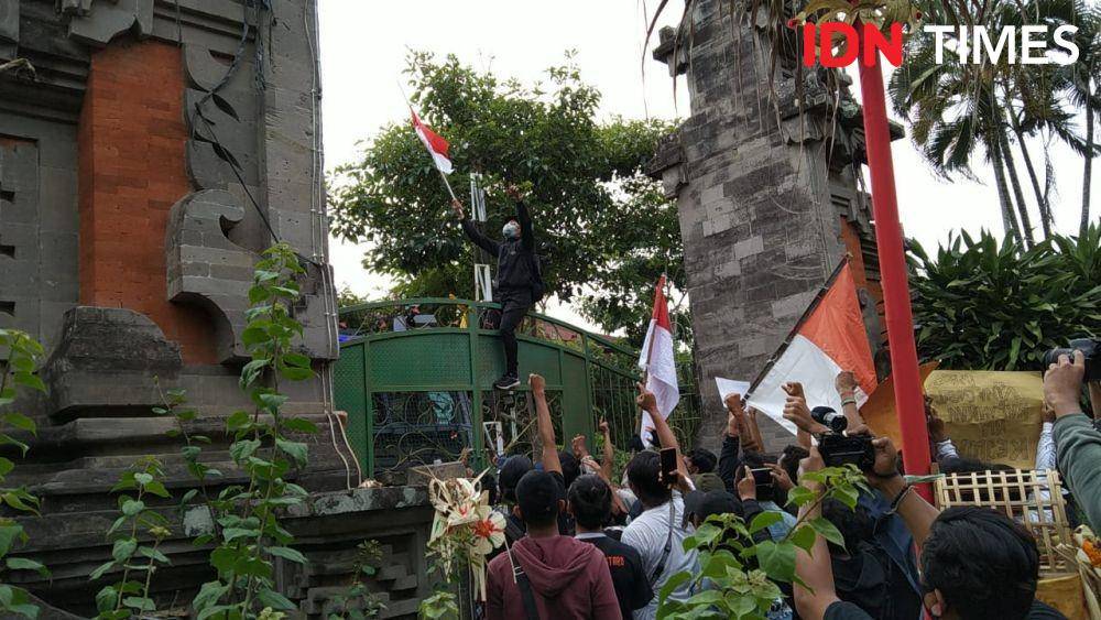 Pengibaran bendera merah putih di atas pagar pintu masuk DPRD Bali (IDN Times/Ayu Afria)