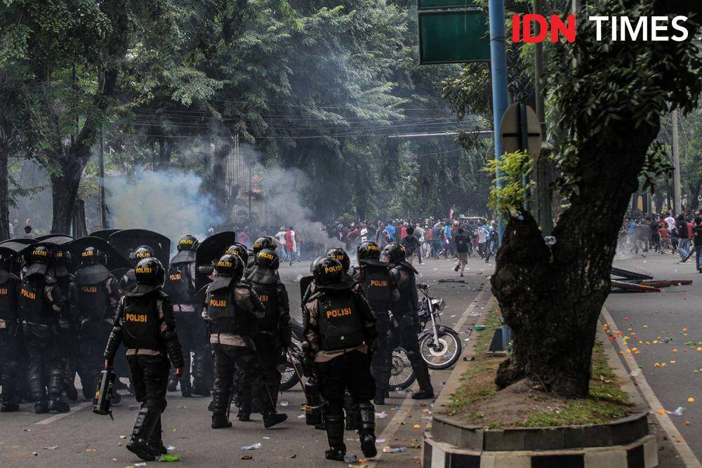 Massa yang dipukul mundur terus melakukan perlawanan, berbalas dengan polisi yang mengobral peluru gas air mata. (IDN Times/Prayugo Utomo)