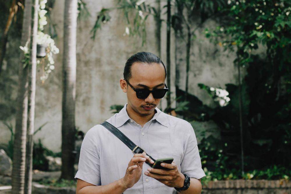 Ilustrasi pria yang sedang melihat handphone (unsplash.com/@kyalloni)