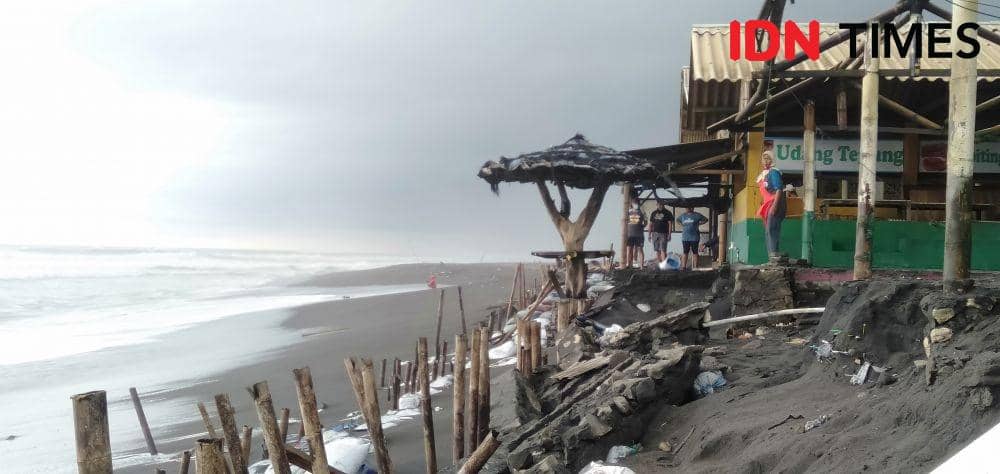 Ilustrasi gelombang pasang terjang bangunan di pesisir pantai. IDN Times/Daruwaskita
