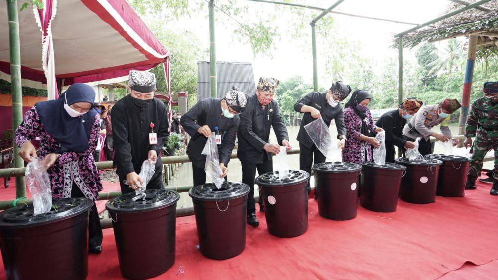 Bupati Banyuwangi Abdullah Azwar Anas saat melakukan tebar benih 40 ribu ikan nila merah di Waduk Lecari. (Dok Banyuwangi)