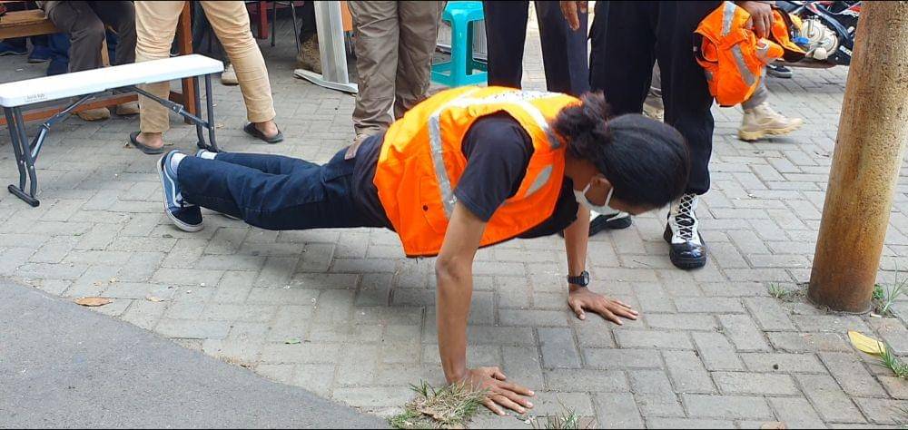 Salah seorang pelanggar protokol kesehatan diberikan sanksi hukuman pushup di Jalan Raya Tanah Baru, Kota Depok. (IDN Times/Dicky)