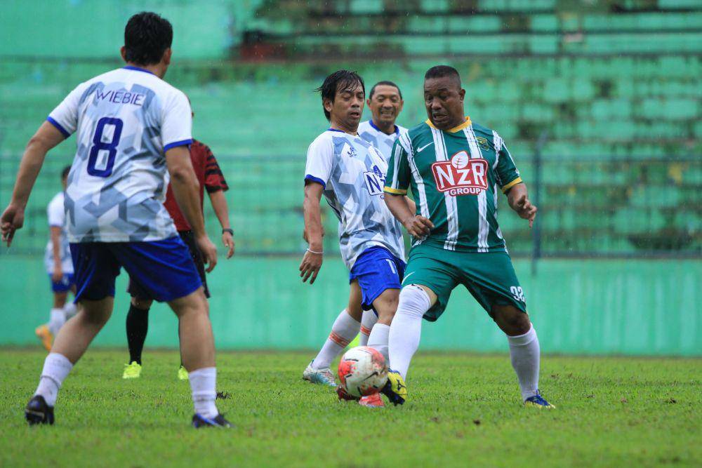 Rian d'Masiv saat berduel perebutan bola dengan legenda Persebaya dan Timnas Indonesia, Chairil Anwar. Dok/NZR