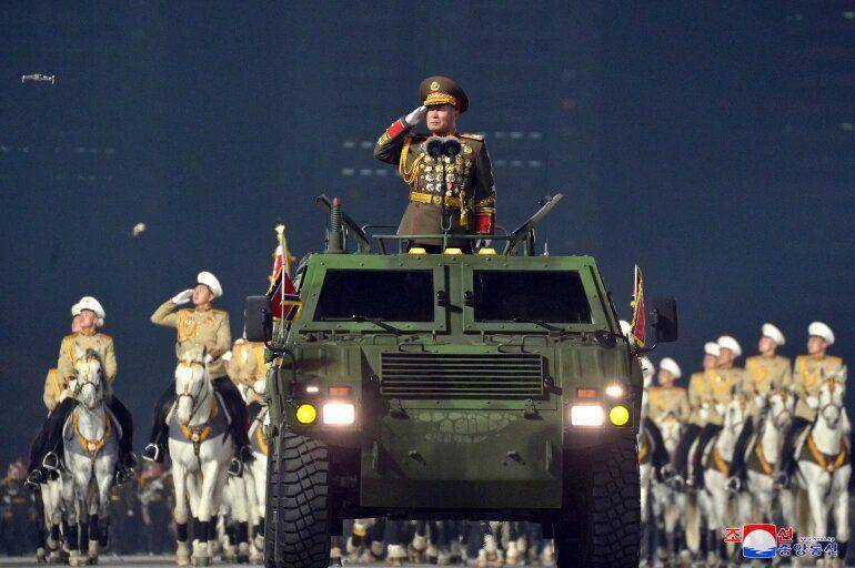 Petugas parade memberi hormat selama parade militer yang memamerkan persenjataan baru berlangsung. Foto: KCNA via Reuters