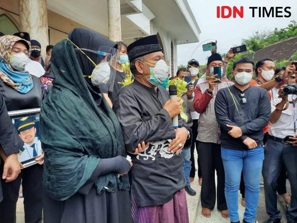 Kedua orangtua Fadly Satrianto saat menerima penyerahan jenazah putranya, Jumat (15/1/2021). IDN Times/Fitria Madia