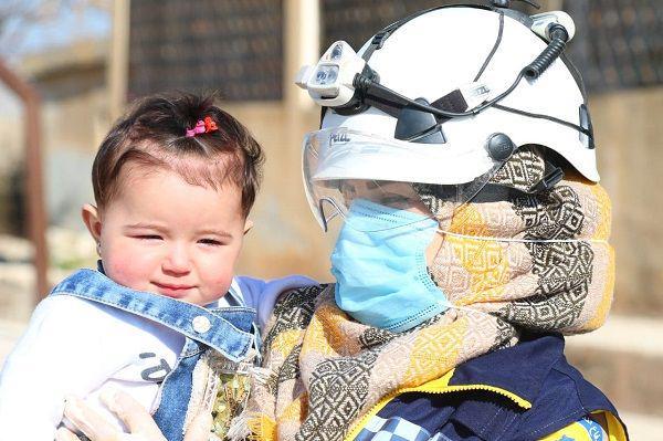 Kelompok pertahanan White Helmet saat menyelamatkan seorang anak yang menjadi korban perang di Suriah. (Twitter.com/SyriaCivilDef)