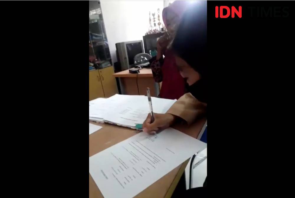 Jeni saat menandatangani surat pernyataan dihadapan pihak sekolah SMK Negeri 2 Padang. Doc. IDN Times