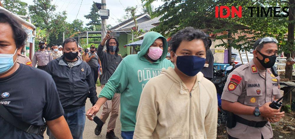 AR tersangka pengancaman penusukan dibawa anggota Polsek Cimanggis dari rumah kediamannya. (IDNTimes/Dicky)