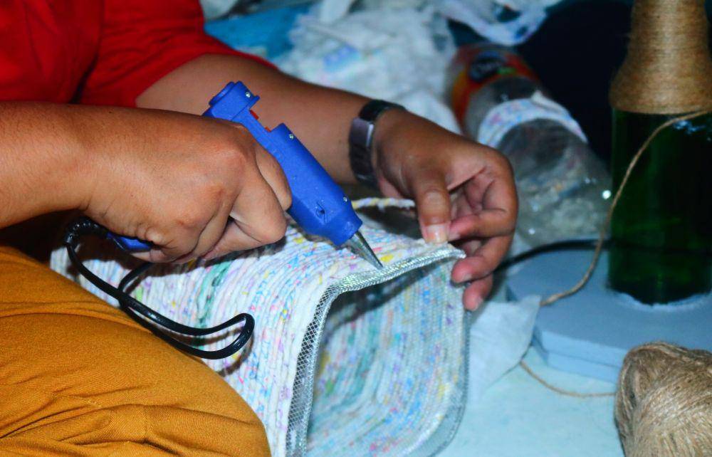 Proses merekatkan limbah popok yang sudah dilinting ke rangka kap lampu. IDN Times/Alfi Ramadana