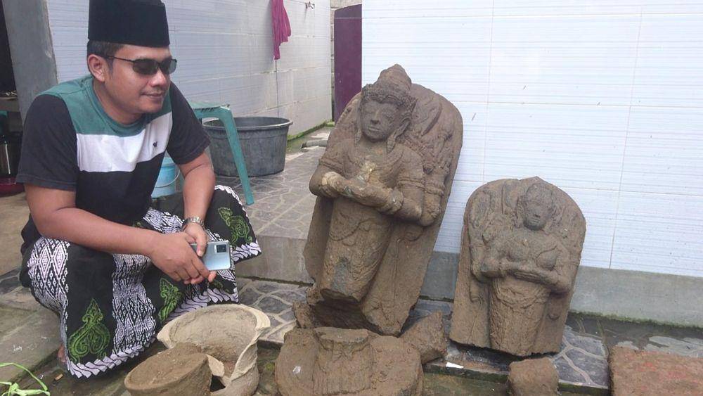 Ahsin Azhari bersama dua arca yang ditemukannya, IDN Times/ Bramanta Pamungkas