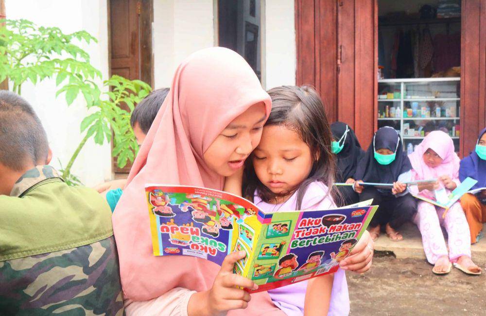 Seorang anak di Gubuk Baca Gading Kembar sedang membaca sebuah buku. IDN Times/Alfi Ramadana